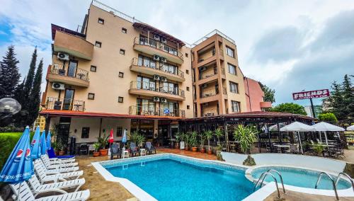 a hotel with a swimming pool in front of a building at Friends Family Hotel in Sunny Beach