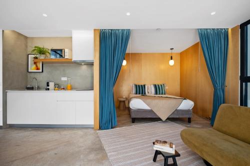 a bedroom with a bed with blue curtains and a couch at The 21 by Homie in Ribeira Brava