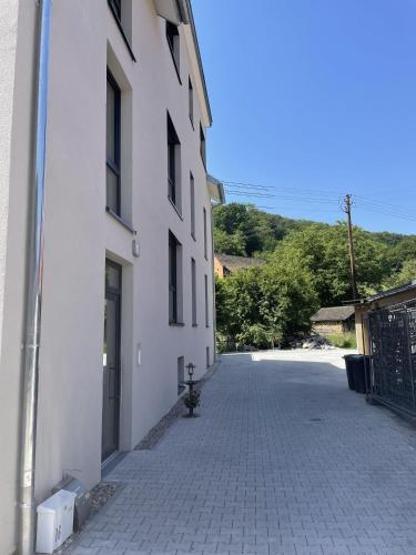 a white building with a gate and a driveway at M&S Apartments - Self Checkin in Degerfelden