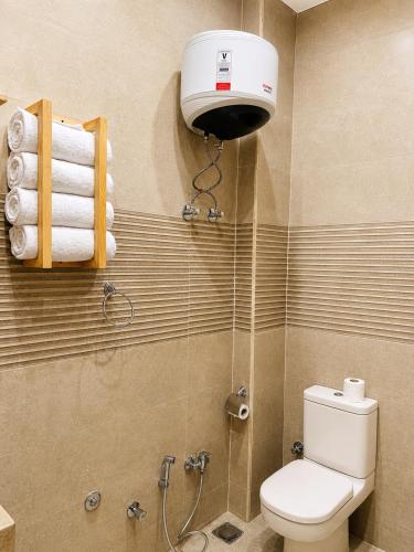 a bathroom with a toilet and a shower with a blow dryer at Happy Oasis Hotel in Siwa