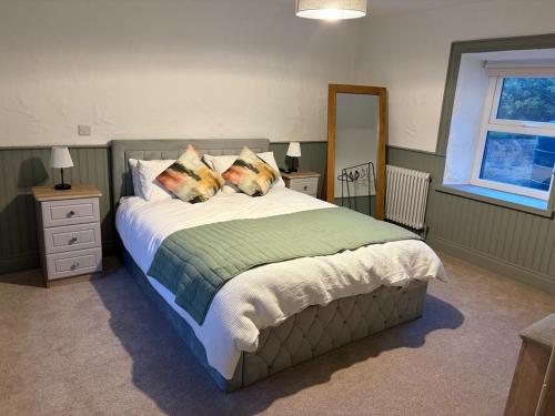 a bedroom with a large bed with two pillows at Hughie Toms Cottage in Greencastle