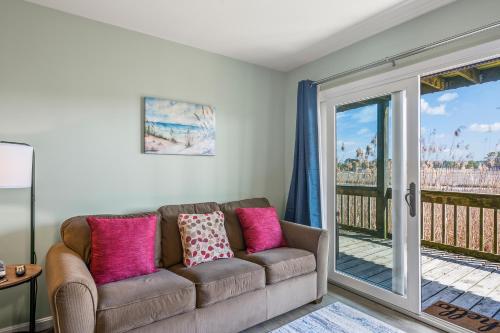 a living room with a couch and a balcony at Assateague Inn 105-S in Deep Hole