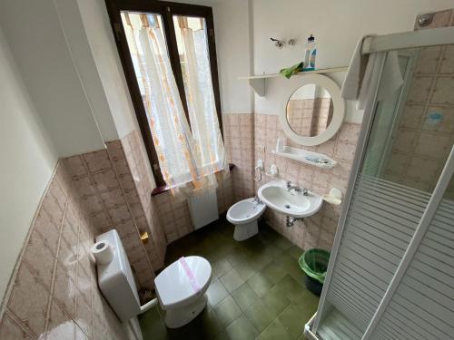 a bathroom with a sink and a toilet and a mirror at Vittoria 1920 - hotel restaurant apartaments in Marzio