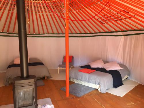 a bedroom with a bunk bed and a stove at Yourte Volcans Puy de Dome in Montfermy