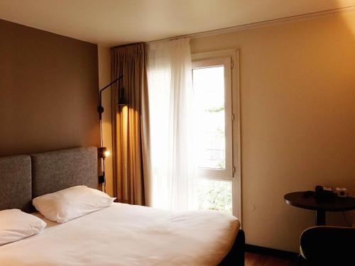 a bedroom with a white bed and a window at ibis Lille Centre Grand Place in Lille