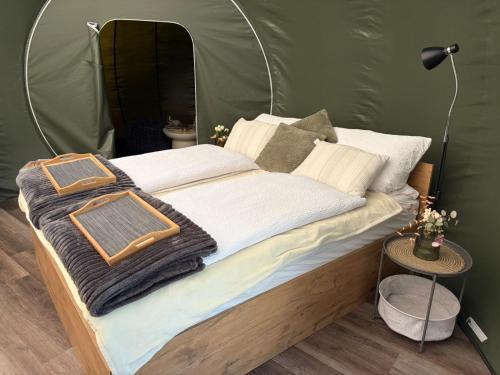 a bed in a green tent with a purse on it at Bubble Tent Altmühltal in Greding
