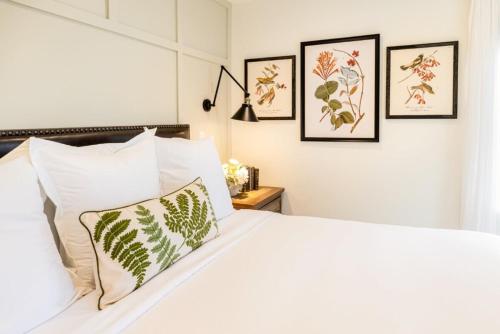 a bedroom with a white bed with four pictures on the wall at Kildahl House - Boutique Farmhouse Suite #2 in West Dundee