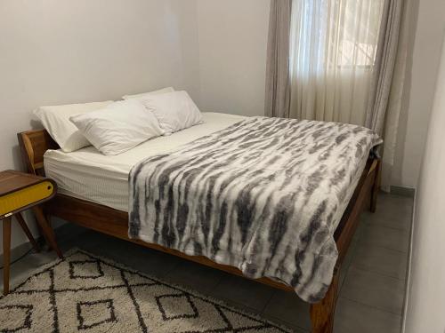 a bed with a black and white blanket on it at Kokoma Apartment in Katima Mulilo in Katima Mulilo