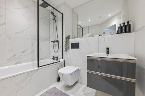 a white bathroom with a toilet and a sink at Spacious North London Flat Sleeps 4 in New Barnet