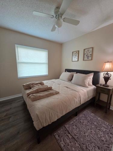 a bedroom with a large bed with a ceiling fan at White Door House! in Winter Haven
