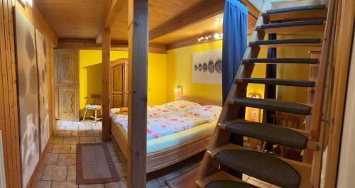 a bedroom with a bunk bed and a spiral staircase at Familija in Straupitz