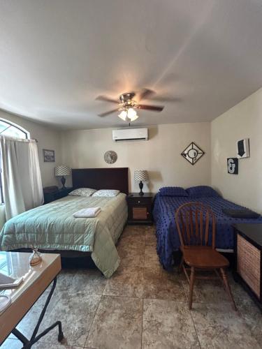 a bedroom with two beds and a ceiling fan at Casa Villafontana in Mexicali