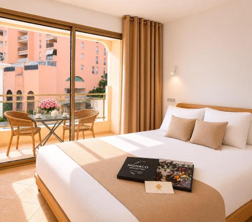 a hotel room with a bed with a book on it at Princess Palace Monaco in Monte Carlo