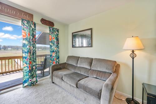 a living room with a couch and a balcony at Assateague Inn 206-S in Chincoteague