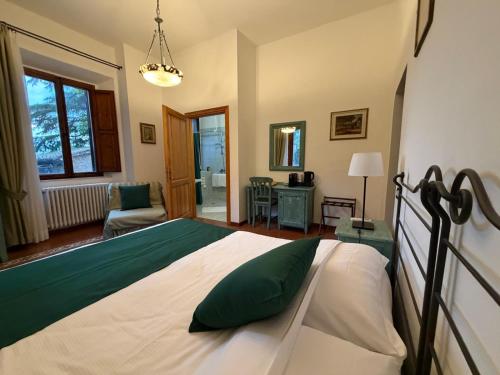 a bedroom with a bed and a living room at Hotel Villa Porta All'Arco in Volterra