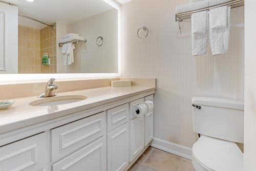 a bathroom with a sink and a toilet and a mirror at Best Western Dorchester Hotel in Nanaimo