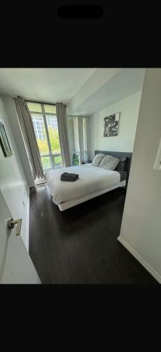 a bedroom with a large bed and a large window at Executive 1 Bedroom Condo sleeps 2 in Toronto