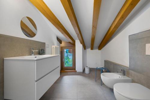 a bathroom with a sink and a toilet and a mirror at Casa Zucchelli in Tenno