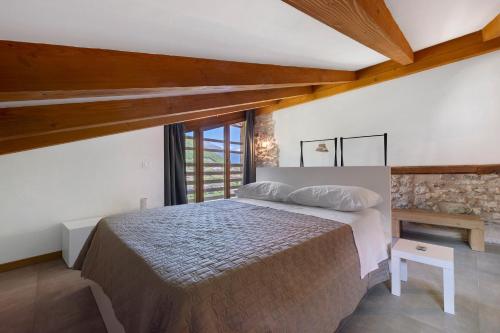 a bedroom with a bed in a room with wooden ceilings at Casa Zucchelli in Tenno