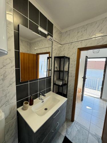 a bathroom with a sink and a mirror at Apartment Niko in Pakoštane