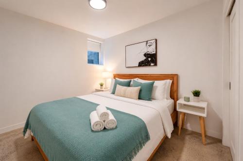 a bedroom with a bed with two towels on it at Jolie Condo Great Location 2BD presented by TripMontreal I in Montreal