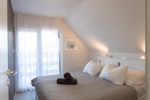 a teddy bear sitting on a bed in a bedroom at Kardos Villa in Szigliget