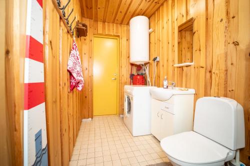 a bathroom with a toilet and a washer and dryer at Kuberi Retro Holiday Home I Sauna Possibility in Pedja