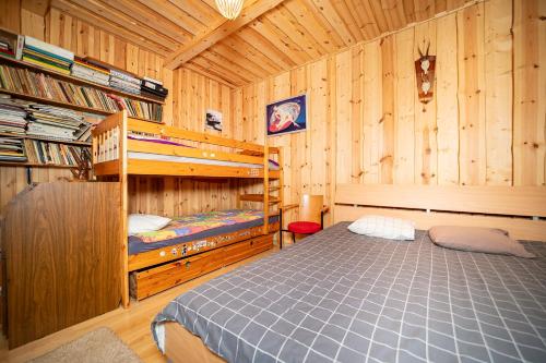 a bedroom with a bed in a wooden cabin at Kuberi Retro Holiday Home I Sauna Possibility in Pedja