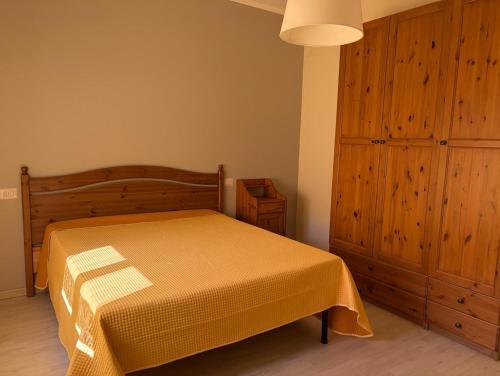 a bedroom with a bed and a wooden cabinet at Ca' Sonenga in Menaggio