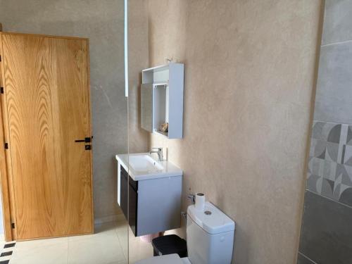 a bathroom with a toilet and a sink and a mirror at Villa neuve pour un séjour agréable à Essaouira in Essaouira
