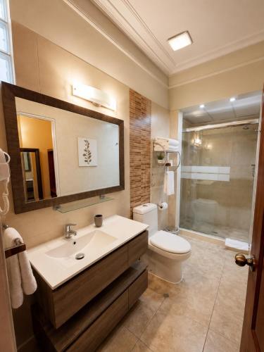 a bathroom with a sink and a toilet and a mirror at Casa de Avila Hotel in Arequipa