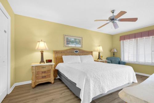 a bedroom with a bed and a ceiling fan at Soundside Holiday Beach Resort in Pensacola Beach