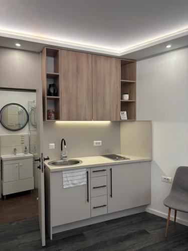 a kitchen with white cabinets and a sink at Villa Aba apartments in Sarajevo