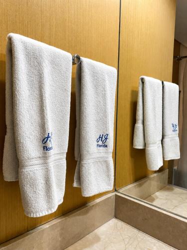 a bathroom with white towels hanging on a wall at Howard Johnson Plaza by Wyndham Buenos Aires Florida Street in Buenos Aires
