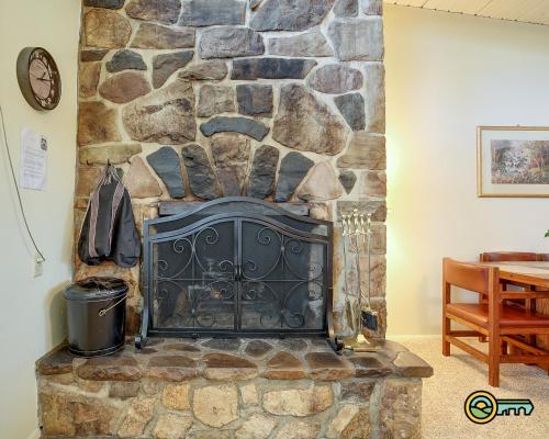 a stone fireplace in the corner of a room at Aspen East Unit #131 in Basye