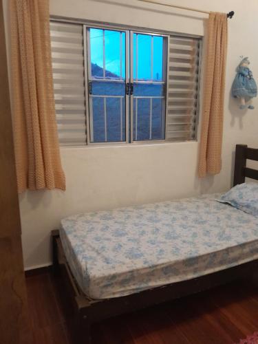 a bedroom with a bed and two windows at Esteira in Iguape