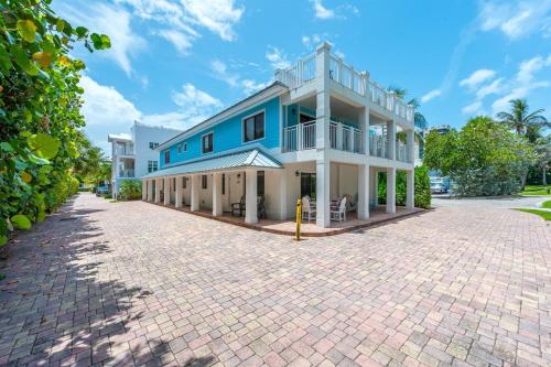 a blue and white house with a brick driveway at ON The Beach Juno! Modern Lux Seaside! in Juno Beach