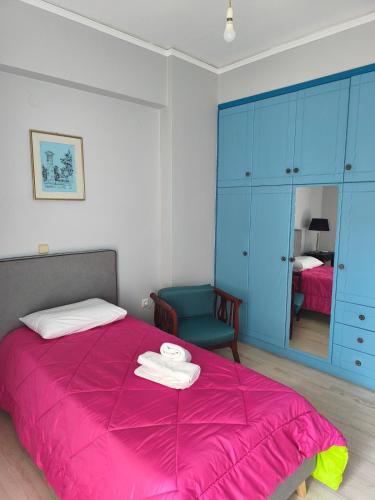 a bedroom with a pink bed and a blue cabinet at Nicolas Luxury Apartment in Amalias