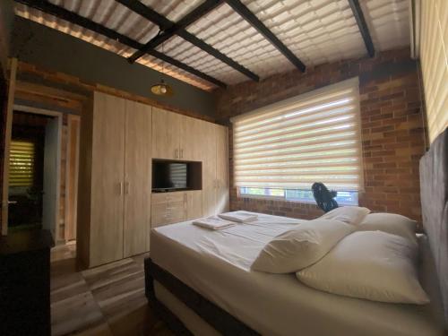 a bedroom with a bed with white pillows at la samara in Anapoima