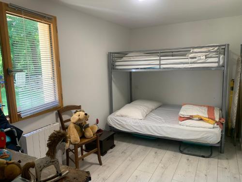 a bedroom with a bunk bed with a teddy bear on a chair at Gîte dans maison Quercynoise in Vaylats