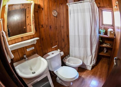 a wooden bathroom with a toilet and a sink at Hosteria Las Cartas in San Carlos de Bariloche