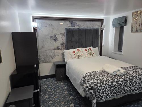 a bedroom with a bed and a black and white comforter at Ababeel Hotel in Birmingham