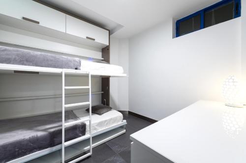 Suites Apartamento 17 في لاس بالماس دي غران كاناريا: غرفة نوم مع سرير بطابقين ومكتب