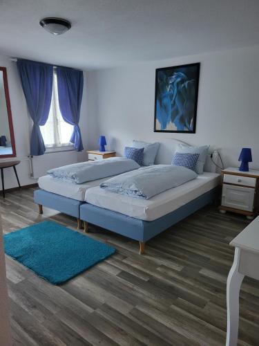 a bedroom with two beds and a blue rug at Ambiente in Emmetten in Emmetten