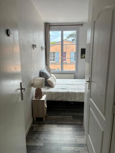 a small bedroom with a bed and a window at Clos fleury in Cluny