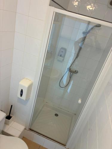 a shower with a glass door in a bathroom at Clos fleury in Cluny