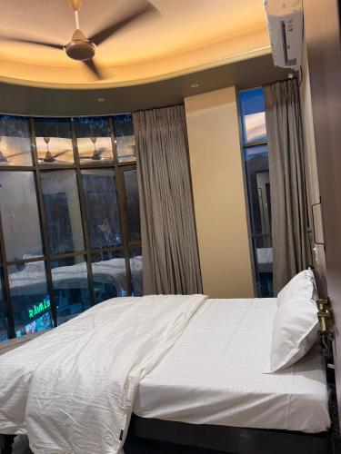 a bedroom with a bed and a large window at Ramona homestay in Kolhapur