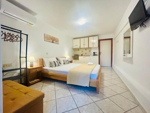 a bedroom with a large bed and a kitchen at Alexandra's House in Skiathos