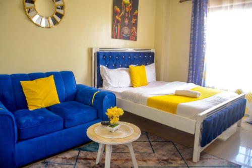 a blue couch and a bed in a room at BA STADEVIEW WEST STUDIOs in Nairobi