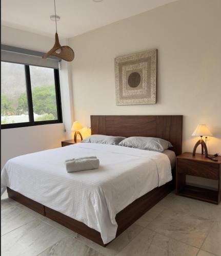 a bedroom with a large bed with white sheets at Nabani Condominios T1 in Santa Cruz Huatulco